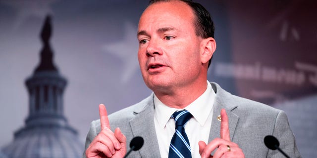 Sen. Mike Lee both hands pointing up in air, at microphone